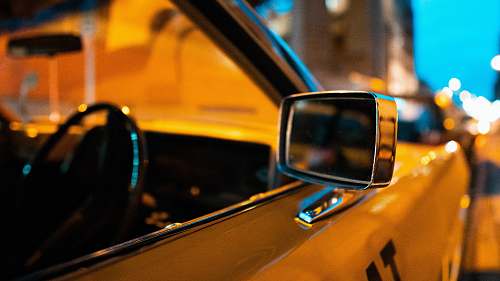 computer close-up photography of yellow car left side mirror electronics